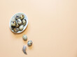 © Anna - Quail eggs in a bowl on a yellow-pink background with copy space.