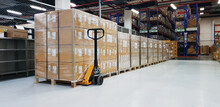 Warehouse With Cardboard Boxes Inside On Pallets Racks, Logistic Center. Huge, Large Modern Warehouse. Warehouse Filled With Cardboard Boxes On Shelves, Boxes Stand On Pallets