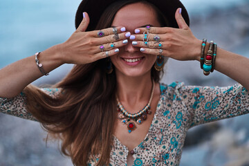 Bohemian chic gypsy smiling happy free woman with manicure wearing hands jewelry accessories, felt hat and dress. Boho detail close up