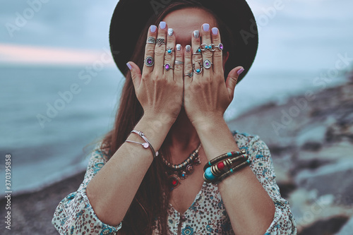 Plakat Bohemian chic gypsy brunette woman with manicure wearing hands jewelry accessories, felt hat and dress. Boho detail close up