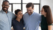 Close up happy overjoyed diverse employees colleagues hugging, standing in modern office, celebrating success, workers business people engaged in team building activity at corporate meeting