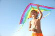 © New Africa - Cute little child playing with kite on sunny day. Beach holiday