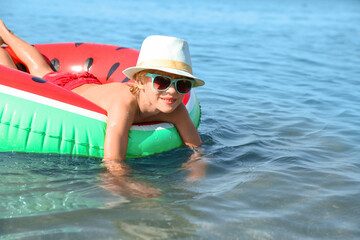 Sticker - Cute little child with inflatable ring in sea on sunny day. Beach holiday