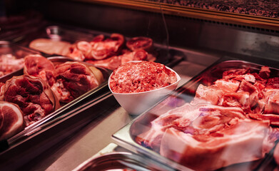 Raw meat in meat shop counter. Different fresh and uncooked products selling.