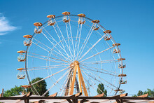 Ferris Wheel And Carousel Top Colorful Fair Rides Against Blue Sky. Vacation Concept