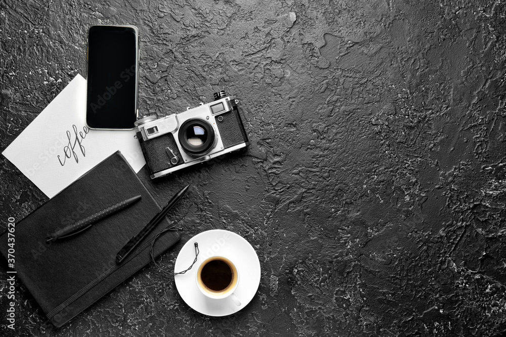 Composition with cup of coffee, photo camera and mobile phone on dark background