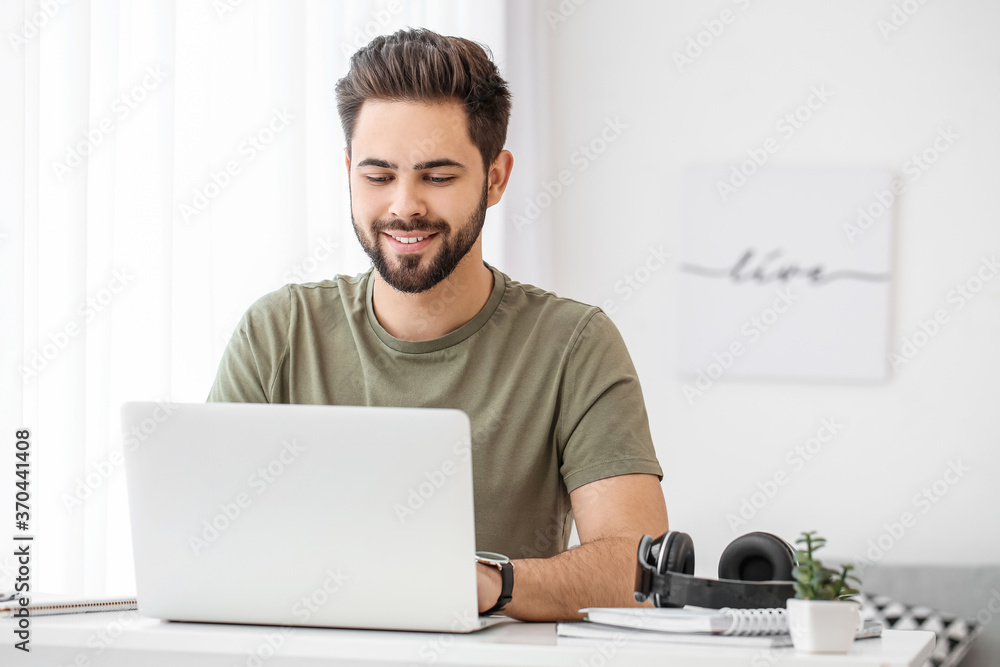 Young man using laptop for online learning at home - obrazy, fototapety, plakaty 