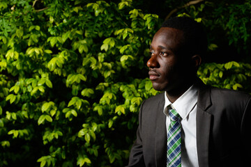 Wall Mural - Young African businessman in the park at night