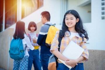 Wall Mural - Young asian female teenager student standing and smiles at school.