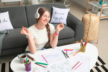 Wall Mural - Young woman coloring picture at home