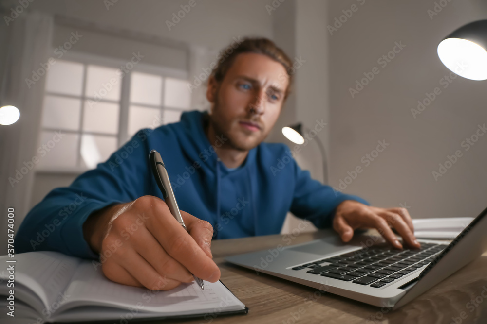 Young man using laptop for online learning at home