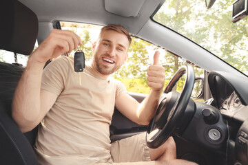 Canvas Print - Happy young man with key in his new car