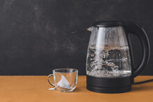 Modern Electric Kettle And Cup With Tea Bag On Table