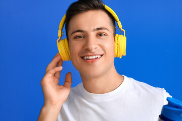 Sticker - Sporty young man with headphones on color background