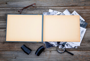 Old yellowed photo album for photos on a wooden table.