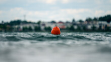 Orange Buoy Swimming In Rippled Water