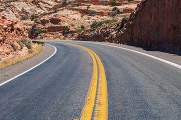 Landscape with orange rocks, sky with clouds and asphalt road in summer. Asphalt texture, way background.