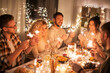 © Syda Productions - holidays, celebration and people concept - happy friends with sparklers having christmas dinner at home