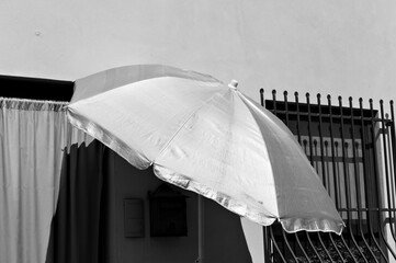 Wall Mural - An isolated sun umbrella in front of the door of a house (Pesaro, Italy, Europe)