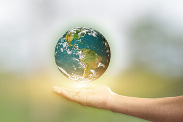 Canvas Print - hand holding planet earth over blur green background. elements of this image are furnished by nasa