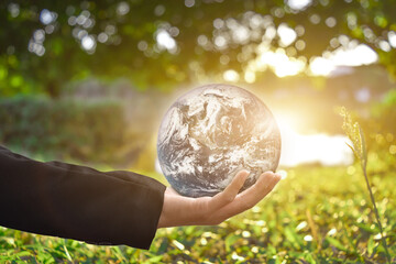 Canvas Print - environment concept: businessman hand holding earth global over green bokeh background. elements of 