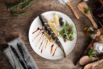 Wall Mural - Gourmet grilled fish with greens lemon and olives