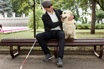 blind young man lovingly stroking guide dog, feeling gratitude for help, friend, full life of impaired, enjoying time.