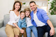 © Prostock-studio - Family Hugging Sitting Together On Couch Smiling To Camera Indoor