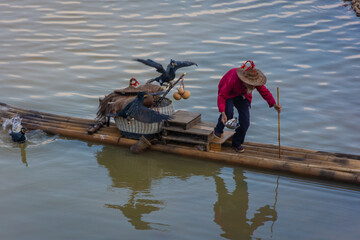 YANGSHUO, CHINA, 6 DECEMBER 2019: Cormorant fisherman on the Li River in Yangshuo