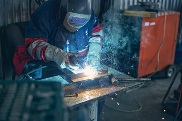 Attentive male person holding blowtorch in his hand