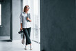 © standret - Woman in formal clothes and with camera in hand standing inside of empty room
