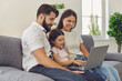 © Studio Romantic - Happy family with laptop doing online shopping in the online store remotely at home.
