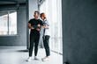 © standret - Woman in formal clothes and with camera in hand standing inside of empty room with man