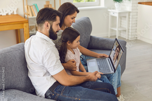 Family doctor online. Happy family consults using video conference computer at home.