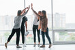 © standret - Woman holding her professional camera. Group of business people in formal clothes standing indoors near big window