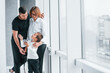 © standret - Woman in formal clothes and with camera in hand standing inside of empty room with man and little boy