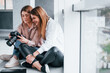 © standret - Two women sitting indoors together and looks at photos on the camera
