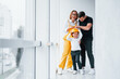 © standret - Female worker in yellow uniform standing indoors with man and child