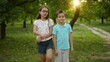 © stockbusters - Smiling brother and sister dancing outdoors. Cute kids in summer park