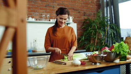 Wall Mural - Woman cutting vegetables for salad in kitchen. Housewife cooking healthy meal.