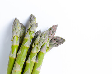 Wall Mural - Bunch of raw asparagus stems isolated on white. Edible Asparagus Officinalis sprouts laid on paper textured background. Close up, copy space, top view, flat lay.