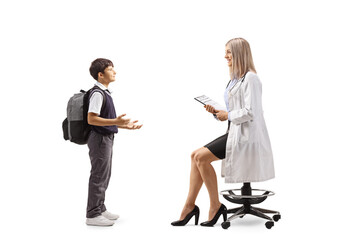 Canvas Print - Schoolboy talking to a young female doctor seated on a chair