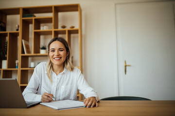 Wall Mural - Portrait of a successful female author at home office.