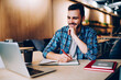 © BullRun - Happy male student dressed in casual look watching funny video online on content website with comedy movies while sitting at campus and learning language using 4g wireless for browsing internet