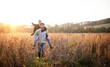 © Halfpoint - Young couple in love on a walk in autumn forest, holding hand ribbon kites.