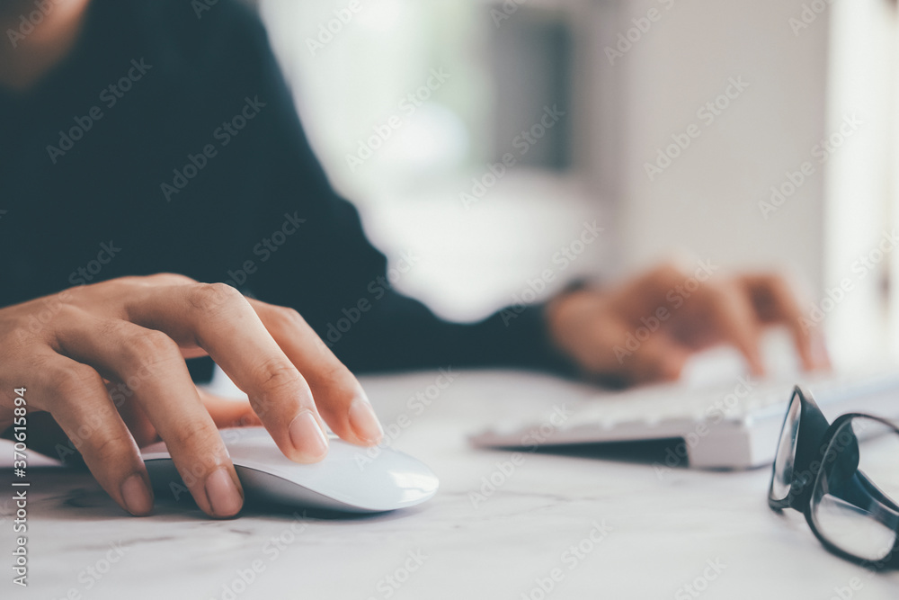Closeup businessman using computer mouse with computer keyboard - obrazy, fototapety, plakaty 