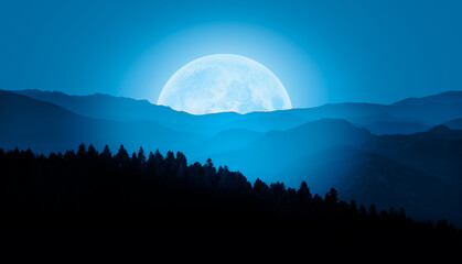 Beautiful landscape with blue misty silhouettes of mountains against super blue moon rising 