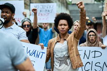 African American Woman With Raised Fist Participating In Black Civil Rights Demonstrations.