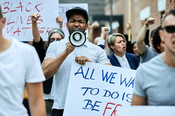 Wall Mural - Displeased black protester shouting through megaphone on anti-racism demonstrations.