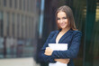 © Евгений Шемякин - Portrait of beautiful business woman, young European gorgeous girl in suit, jacket standing outdoors with documents, papers in hands. Attractive positive office worker, lady looking at camera, smiling